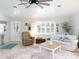 Bright living room featuring a comfortable sofa, armchair, and a large window at 30 Jamestown Ave, Englewood, FL 34223