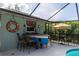 Entertainer's patio featuring a bar in the shape of a boat, with seating and a covered pool area at 30 Jamestown Ave, Englewood, FL 34223
