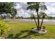 Picturesque view of community pond surrounded by green lawns and tropical landscaping at 30 Jamestown Ave, Englewood, FL 34223