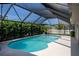 Sparkling pool with a screened enclosure, surrounded by lush greenery and a spacious deck at 30 Jamestown Ave, Englewood, FL 34223