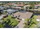 An aerial view shows a waterfront home with lush landscaping, a paver driveway, and a screened-in pool at 314 Oakwood Cir, Englewood, FL 34223