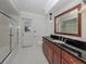 Bathroom with tiled floors, a large mirror, vanity, and a glass-enclosed shower at 314 Oakwood Cir, Englewood, FL 34223