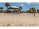 Beach scene with a volleyball net, picnic tables, and a covered gazebo under a bright blue sky at 314 Oakwood Cir, Englewood, FL 34223