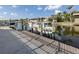 View of boat lift and dock on the canal with clear sky at 314 Oakwood Cir, Englewood, FL 34223