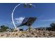 Outdoor metal conch shell art sculpture set on rocks, illuminated by modern lighting, against a bright blue sky at 314 Oakwood Cir, Englewood, FL 34223
