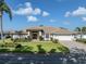 Stunning single-story home features manicured landscaping, a paver driveway, and a two-car garage at 314 Oakwood Cir, Englewood, FL 34223