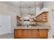 A kitchen with a large granite countertop island, wooden cabinets, and stainless steel appliances at 314 Oakwood Cir, Englewood, FL 34223