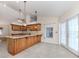 A kitchen with a granite countertop island, wooden cabinets, and a window above the sink at 314 Oakwood Cir, Englewood, FL 34223