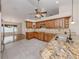 Open concept kitchen with wooden cabinets, stainless steel appliances, granite countertops, and an adjacent dining area at 314 Oakwood Cir, Englewood, FL 34223