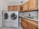 Laundry room with side-by-side washer and dryer, plenty of cabinet space, and granite countertops at 314 Oakwood Cir, Englewood, FL 34223