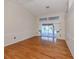 An open living room with wood floors and neutral walls with sliding glass doors leading to the pool at 314 Oakwood Cir, Englewood, FL 34223