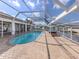 In-ground pool with brick surround, screened-in enclosure, and views of the waterway at 314 Oakwood Cir, Englewood, FL 34223
