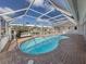 In-ground pool with brick surround, screened-in enclosure, and views of the canal at 314 Oakwood Cir, Englewood, FL 34223