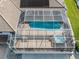 Aerial view of the screened pool with a hot tub and tile roof on a waterfront home at 314 Oakwood Cir, Englewood, FL 34223