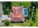 Aerial view of a home with a tile roof, screened pool enclosure, mature landscaping, and paved driveway at 316 Signorelli Dr, Nokomis, FL 34275