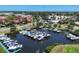 Aerial view of a boat dock filled with boats, surrounded by lush trees and neighborhood homes at 316 Signorelli Dr, Nokomis, FL 34275