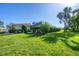Expansive backyard features manicured lawn, hedge and glimpses of the house, pool and palm trees at 316 Signorelli Dr, Nokomis, FL 34275