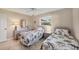 Bedroom featuring two twin beds with floral bedding and a dresser with mirror at 316 Signorelli Dr, Nokomis, FL 34275