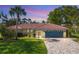 Charming home exterior with a colorful two-car garage, tiled roof, manicured lawn, and paved driveway at 316 Signorelli Dr, Nokomis, FL 34275