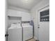 Laundry room with washer, dryer, white cabinets and a door to the exterior at 316 Signorelli Dr, Nokomis, FL 34275
