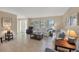 Cozy living room with tile floors, comfortable sofas, and plenty of natural light from large windows at 316 Signorelli Dr, Nokomis, FL 34275