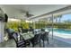Enclosed patio area with a glass table and view of the yard and swimming pool at 316 Signorelli Dr, Nokomis, FL 34275