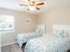 Comfortable bedroom with matching twin beds, side tables, and an airy ceiling fan at 3255 Beneva Rd # 102, Sarasota, FL 34232