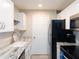 Well-lit kitchen featuring white cabinets, stainless steel appliances, and a full size fridge at 3255 Beneva Rd # 102, Sarasota, FL 34232