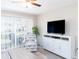 Bright living room showcasing a modern entertainment setup, a ceiling fan and an armchair at 3255 Beneva Rd # 102, Sarasota, FL 34232