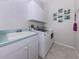 Laundry room with tile flooring, white cabinets, utility sink and modern washer and dryer set at 396 Lansbrook Dr, Venice, FL 34292