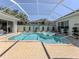 Backyard with screened-in pool and spa, brick pavers, mature landscaping, and beautiful surroundings at 396 Lansbrook Dr, Venice, FL 34292
