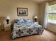 Comfortable bedroom with a sailboat painting, two side tables and a large window at 4244 Vicenza Dr # D34, Venice, FL 34293