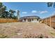 Wide shot of the backyard with a wooden fence enclosing the screened-in back porch at 429 Riviera St, Venice, FL 34285