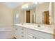 Bathroom featuring double sinks, large mirror, and soaking tub at 429 Riviera St, Venice, FL 34285