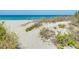 Sandy beach path with native beach vegetation overlooking the clear blue ocean at 429 Riviera St, Venice, FL 34285