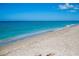 Turquoise ocean meets sandy beach under a clear blue sky, inviting relaxation and enjoyment at 429 Riviera St, Venice, FL 34285