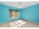 Bright blue bedroom features a ceiling fan and window with blinds at 429 Riviera St, Venice, FL 34285