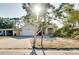 Quaint single-story home featuring a two-car garage, lush front yard foliage, and a welcoming entrance at 429 Riviera St, Venice, FL 34285