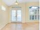 Bright and airy living area with tile flooring, white curtains, and french doors leading to outdoor space at 429 Riviera St, Venice, FL 34285