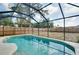 Inviting pool with a clear blue water surrounded by a screened enclosure and a well-kept backyard at 429 Riviera St, Venice, FL 34285