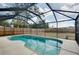Sparkling blue swimming pool enclosed with a black screen and a well-maintained pool deck at 429 Riviera St, Venice, FL 34285