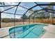 Screened-in pool area with a clear blue pool and views of the surrounding lush landscape at 429 Riviera St, Venice, FL 34285
