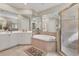 Well-lit bathroom featuring a bathtub, shower, and tile flooring at 4403 Via Del Villetti Dr, Venice, FL 34293