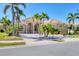 Inviting front view of a luxury home featuring a paved driveway, arched entryway, and lush tropical landscaping at 4403 Via Del Villetti Dr, Venice, FL 34293