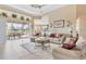Bright and airy living room with tile floors, access to lanai, and comfortable seating at 4403 Via Del Villetti Dr, Venice, FL 34293