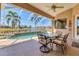 This screened patio area looks out onto a water view and has comfortable seating for outdoor dining at 4403 Via Del Villetti Dr, Venice, FL 34293