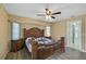 This is a main bedroom with a ceiling fan, wood floors, and ornate, wooden furniture at 447 Rotonda Cir, Rotonda West, FL 33947