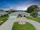 Charming single-story home featuring a circular driveway, lush landscaping, and a two-car garage, perfect for suburban living at 447 Rotonda Cir, Rotonda West, FL 33947