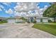 Well-manicured home with updated driveway and landscaping, showcasing curb appeal at 447 Rotonda Cir, Rotonda West, FL 33947