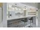 Stylish kitchen with white cabinets, modern countertops, pendant lighting, and a breakfast bar with stools at 447 Rotonda Cir, Rotonda West, FL 33947